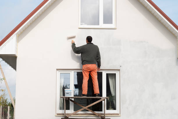 construction worker is painting a wall with a roller