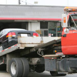 Tow truck bringing a car at the car repair shop.