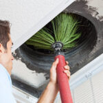 Man cleaning air ducts in home.