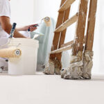 painter man at work with a roller, bucket and ladder, bottom view