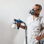 worker-painting-wall-with-spray-gun-white-color_176420-4733