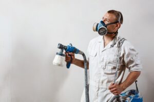 worker-painting-wall-with-spray-gun-white-color_176420-4733