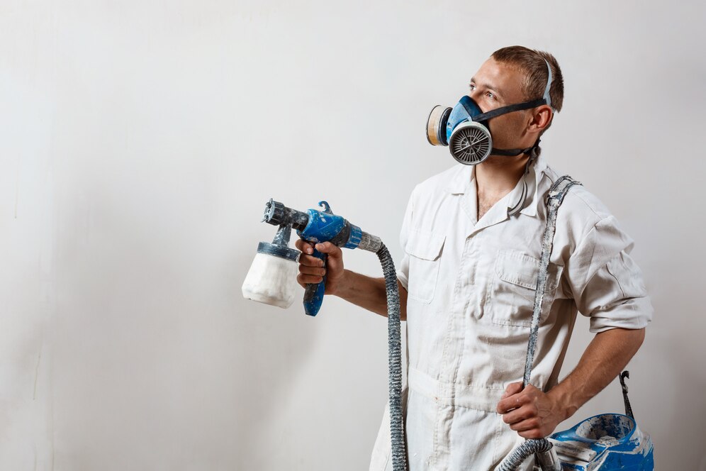 worker-painting-wall-with-spray-gun-white-color_176420-4733
