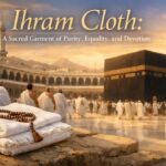 Pilgrims in white Ihram cloth walking around the Kaaba during sunset, with folded Ihram garments and prayer beads placed in the foreground, symbolizing purity, equality, and devotion