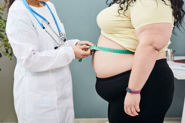obesity-unhealthy-weight-nutritionist-inspecting-a-womans-waist-using-a-meter-tape-to (1)
