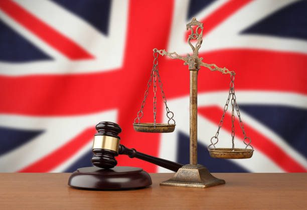 United Kingdom flag and golden scale with a judge's gavel