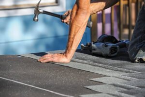 close up on worker using hammer repairing roof