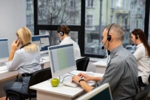 colleagues-working-together-call-center-with-headphones (1)