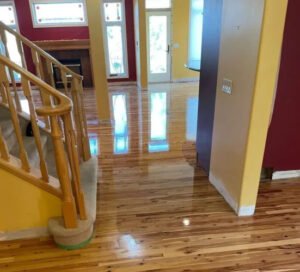 Professional technician using a dustless hardwood floor refinishing machine in a Calgary home.