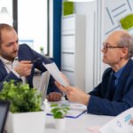 Senior entrepreneur discussing with coworker