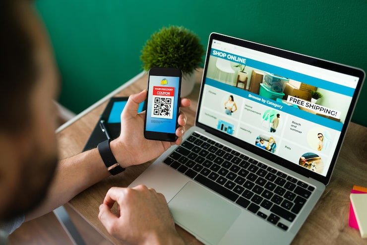 young-man-using-discount-coupon-his-smartphone-some-online-shopping-laptop_662251-2177